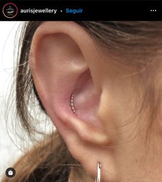 a close up of a person's ear with two small hoops attached to it