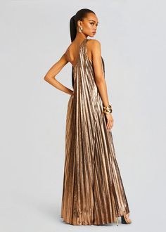 Dazzle in our stunning Kensley Dress, designed with a flattering one-shoulder neckline and cascading pleats for an effortlessly elegant look. Perfect for formal events, evening soirées, and special occasions, this flowing gown is sure to turn heads. Shown here in Metallic Bronze. 95% Polyester, 5% Spandex Made in China Metallic Bridesmaid Dresses, Flowing Gown, Bridal Reception Dress, Dress Night Out, Bride Bachelorette, Bachelorette Party Bride, Rehearsal Dress, Reception Dress, Bridesmaid Gown