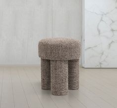 two round stools sitting on top of a hard wood floor next to a white wall