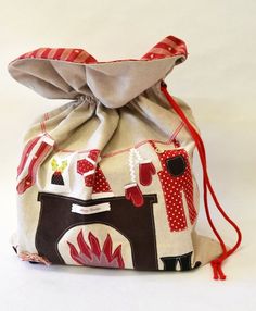 a drawstring bag with red and white designs on the front, sitting on a white surface