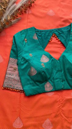 Product Descriptions: Green and blue silk saree is having copper zari motifs all over the saree and green rich copper zari floral motif worked pallu. Saree comes with green silk hand work blouse having highlighted works for front & sleeves as shown