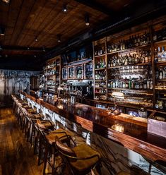 an empty bar with many bottles on the shelves