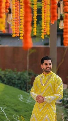 a man dressed in yellow standing under an orange and yellow decoration