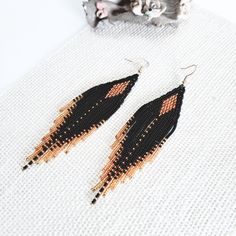 ❤️ Look gorgeous in these long beaded fringe earrings made in classic colors of black and gold. Made with opaque black and sparkly golden seed beads to give it a unique look. Wear it with a matching dress or mix and match with your favorite outfit.   Earring Length: 5 inches ❤️ Handmade with great care and attention to detail using high quality czech seed beads and woven in strong nylon beading thread. The earrings are attached with gold plated ear wire for ease of wear. Each bead is picked up using a needle and woven to create a distinct chevron pattern. ❤️ Buy for yourself or it makes for a great gift for birthday, anniversary or any other occasion. Fringe Beaded Earrings, Beaded Fringe Earrings, Beading Thread, Native American Beaded Earrings, Hippie Look, Beading Ideas, Native American Beading, Earring Tutorial, Handmade Wire Jewelry