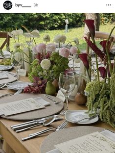 a table set with place settings and flowers