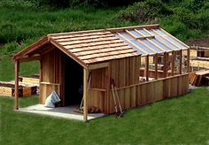 a small wooden shed sitting on top of a lush green field