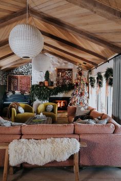 a living room filled with furniture and a fire place next to a christmas tree on the wall