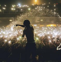 a man standing in front of a crowd with lots of lights on his head and hands