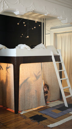 there is a bunk bed with curtains on it and a ladder to the bottom level