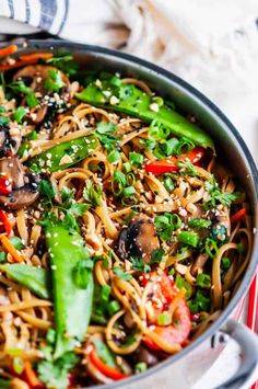 a pan filled with noodles and vegetables on top of a table