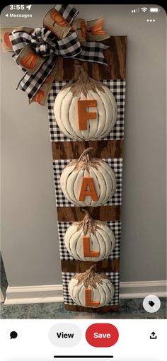 a wooden sign with pumpkins hanging from it's sides and the letter f on top