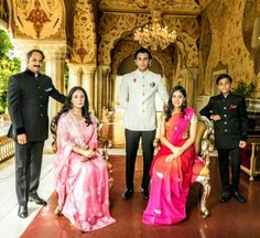 a group of people standing next to each other in front of a chandelier