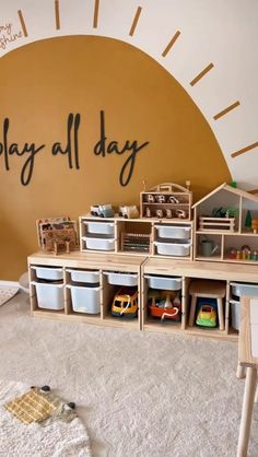 a play room with toys and storage bins on the floor in front of a wall that says play all day