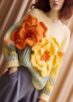 a woman wearing a sweater with flowers on it