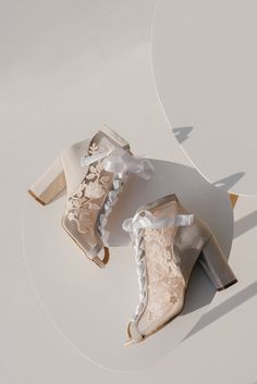 two pairs of high heeled shoes sitting on top of a white table next to each other