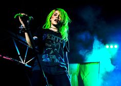 a woman with green hair standing on stage