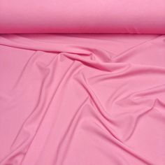 a pink sheet that is laying on top of a bed