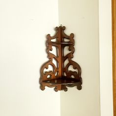 an ornate wooden shelf mounted to the side of a wall