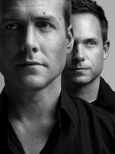 black and white photograph of two men looking at the camera with one man's face partially obscured by his shirt