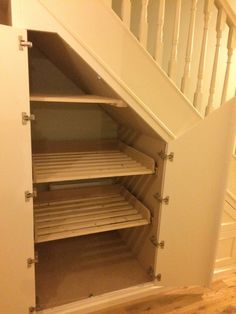 an open closet under the stairs in a house