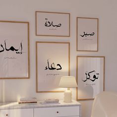 arabic calligraphy on the wall above a white dresser with a lamp in front of it