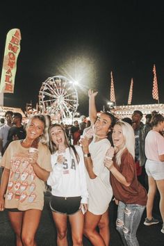 some people are posing for a photo at an amusement park with ferris wheel in the background