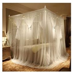 a canopy bed with white sheer curtains and lights on the top, in a bedroom