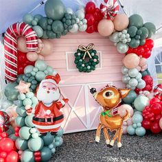 a christmas scene with balloons and decorations in the shape of santa's house on display