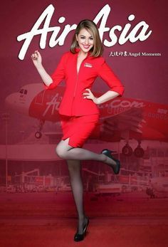 a woman in a red dress and black shoes posing for the camera with an air asia advertisement behind her