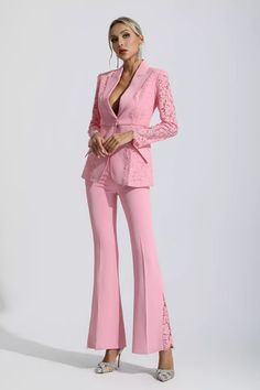 a woman in pink pants and jacket standing on a white background with her hands on her hips