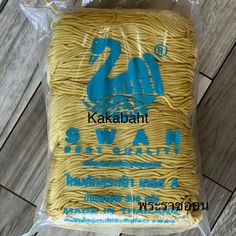 a bag of yellow twine on top of a wooden floor