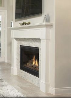 a living room with a fire place and flat screen tv on the wall above it