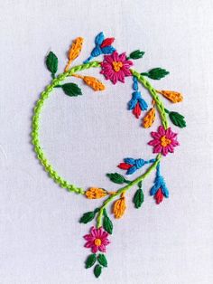 an embroidered circle with colorful flowers and leaves