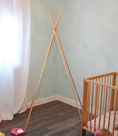 a child's room with a crib, cot and wooden toys on the floor