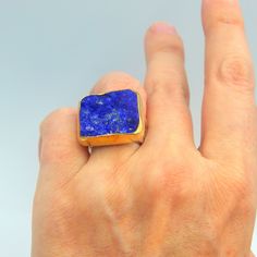 Lapis Lazuli raw gemstone big statement ring made out of 18 karat Gold plated Sterling Silver. 100% Handmade Jewellery. LAPIS LAZULI: The sweet sounding name of this gem is composed of 'Lapis', the Latin word for stone, and 'Azula', which comes from the Arabic and means 'blue'. Historians believe the link between humans and lapis lazuli stretches back more than 6,500 years. The gem was treasured by the ancient civilizations of Mesopotamia, Egypt, China, Greece, and Rome. They valued it for its v Unique Rectangular Gemstone Ring, Unique Rectangular Natural Stone Rings, Unique Rectangular Rings With Natural Stones, Elegant Rectangular Rings With Natural Stones, Elegant Rectangular Natural Stone Rings, Statement Rings Unique, Ring Rectangle, Big Statement Rings, Bezel Jewelry