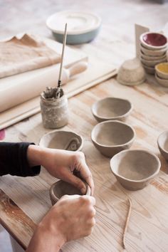 a person is making bowls on a table