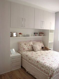 a cat laying on top of a bed in a room with white walls and wooden floors