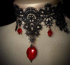 Gothic Black Lace Choker.... This is an exquisite black lace choker adorned with deep ruby-red crystals that glisten like drops of blood. The lace is intricate, with gothic-inspired patterns, adding a touch of dark elegance. The choker is adjustable, ensuring a comfortable fit for all neck sizes. The ruby-red crystals catch the light beautifully, creating a striking contrast against the black lace, perfect for a gothic wedding or as a statement piece for Halloween. Its timeless design embodies b Red Gothic Jewelry For Party, Handmade Gothic Choker For Wedding, Black Vampire Style Choker As Gift, Red Choker For Halloween Party, Handmade Vampire Style Jewelry For Party, Vintage Red Choker For Party, Gothic Choker For Formal Occasions, Red Gothic Choker For Festivals, Elegant Handmade Halloween Choker