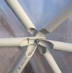 the underside of a white metal structure with water droplets on it