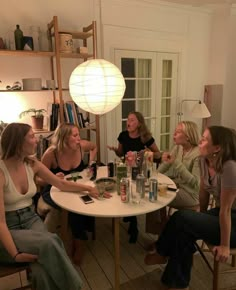 four women sitting around a table talking and drinking