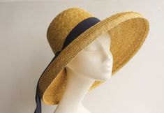 Mirabele Natural Straw Sun Hat with face shading wide brim, deep crown in golden antique colour straw and classic 'darkest navy petersham ribbon decoration. Travel in style. A chic, romantic and versatile hat for country walks, gardening, city strolls and outdoor activities... sea and sand... for summer gatherings. Team up with play suits, printed tea dresses, neutral ensembles, beach wear, trouser suits or smart jeans and wear it all summer long. Limited edition.   SHIPPING All shipments will b Gold Brimmed Straw Hat, Gold Wide-brim Straw Hat For Kentucky Derby, Gold Wide Brim Straw Hat For Kentucky Derby, Gold Brimmed Straw Hat For Kentucky Derby, Gold Wide Brim Straw Hat, Adjustable Gold Straw Hat For Kentucky Derby, Gold Brimmed Sun Hat For Kentucky Derby, Adjustable Gold Brimmed Boater Hat, Gold Short Brim Hat For Church