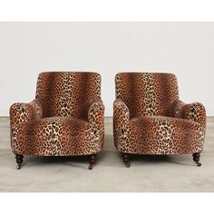 a pair of leopard print chairs on casteors