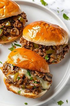 three sloppy joe sliders on a white plate