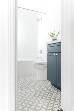 a white and blue bathroom with an open door