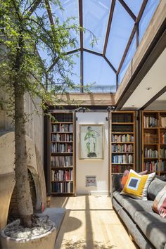 a living room filled with furniture and bookshelves covered in lots of bookcases