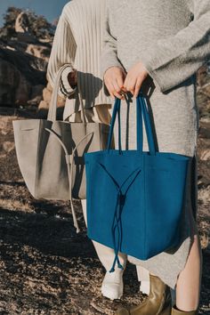 a woman holding a blue bag in her hands