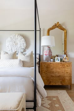 a bedroom with a bed, dresser and mirror on the wall next to each other