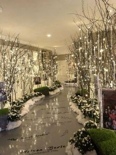 an indoor walkway decorated with christmas lights and greenery