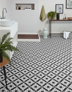 a bathroom with black and white tiles on the floor