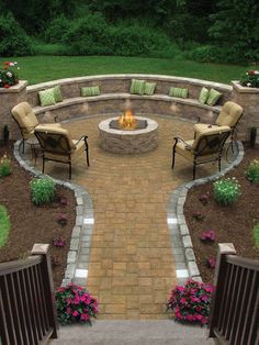 a fire pit surrounded by chairs and flowers